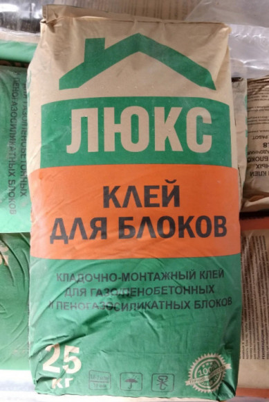 Живое фото мешка клея для блоков ЛЮКС (25 кг) на поддоне нашего склада в Рыбном. Упаковки герметичны, смесь хранится в надлежащих сухих условиях и готова к отгрузке на ваш объект.